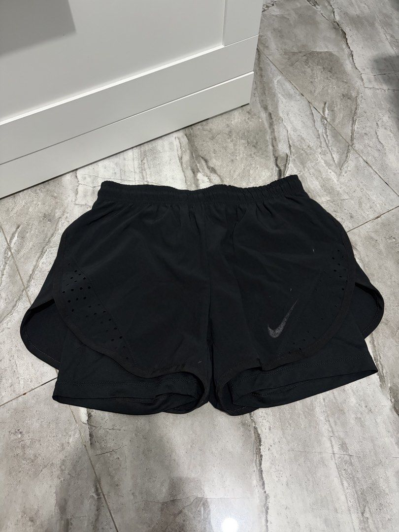 Nike Black Athletic Running Shorts (Category: Shorts) located in Bulacan. Submitted by lenggayy (Listing ID 1466927644, Image 1). Description: - Color: Black - Comfort: Built-in inner lining and stretchy elastic waistband - Breathability: Perforated side panels for extra ventilation - Design: Lightweight fabric with a subtle reflective Nike swoosh - Condition: Brand new / Excellent quality - Perfect for: Gym workouts, running, and daily training.