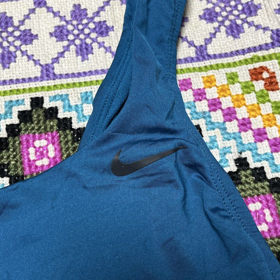 Nike Blue One-Piece Swimsuit (Category: Bikinis & Swimsuits) located in Dagupan City. Submitted by vernzkee (Listing ID 1466817989, Image 2). Description: - Brand: Nike - Style: One-piece swimsuit in solid blue - Neckline: Scoop neck with iconic black swoosh logo on the front strap - Back Design: Open back with a sporty striped accent band on the lower back - Fit & Cut: Standard cut leg openings with smooth, stretchy fabric for maximum comfort - 