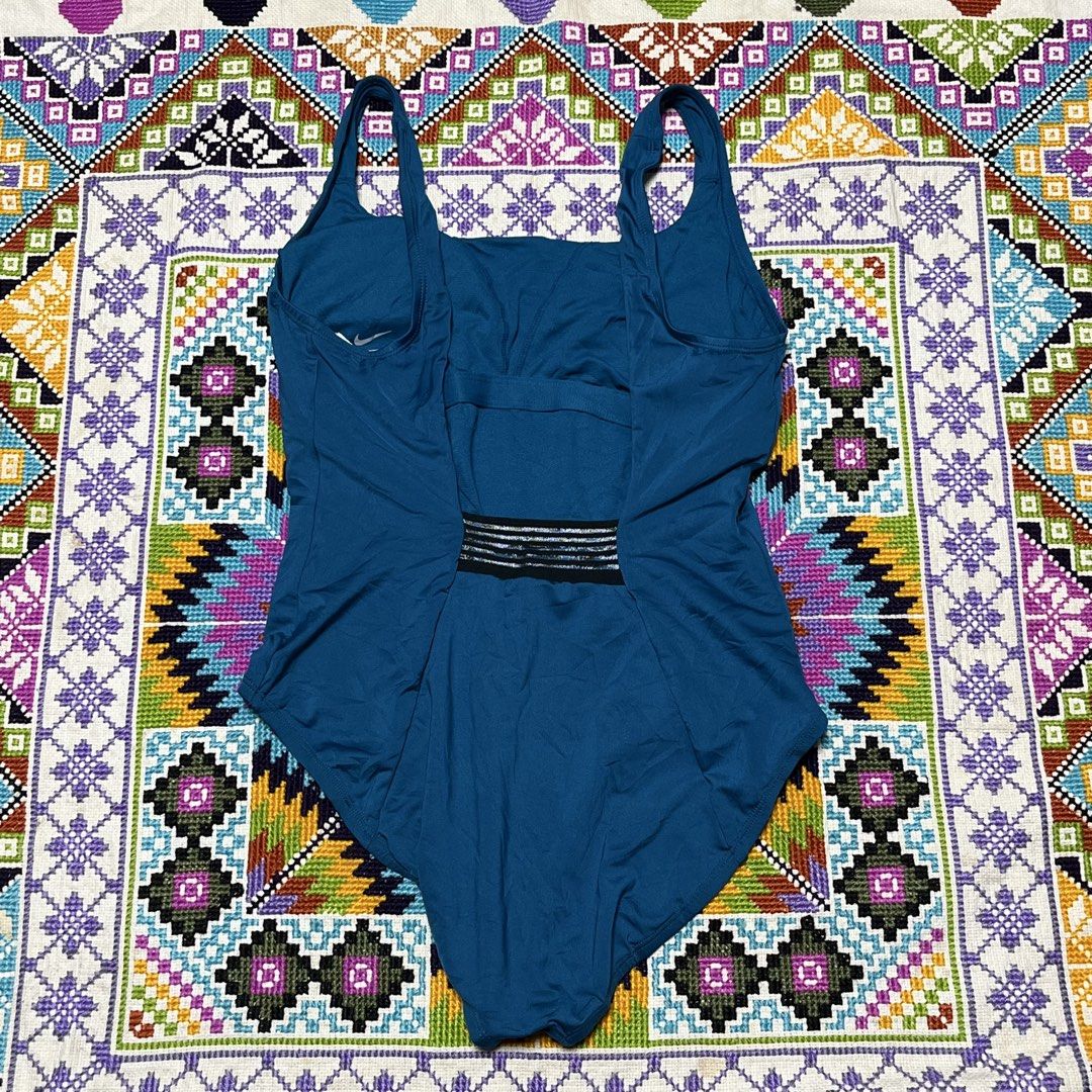 Nike Blue One-Piece Swimsuit (Category: Bikinis & Swimsuits) located in Dagupan City. Submitted by vernzkee (Listing ID 1466817989, Image 3). Description: - Brand: Nike - Style: One-piece swimsuit in solid blue - Neckline: Scoop neck with iconic black swoosh logo on the front strap - Back Design: Open back with a sporty striped accent band on the lower back - Fit & Cut: Standard cut leg openings with smooth, stretchy fabric for maximum comfort - 