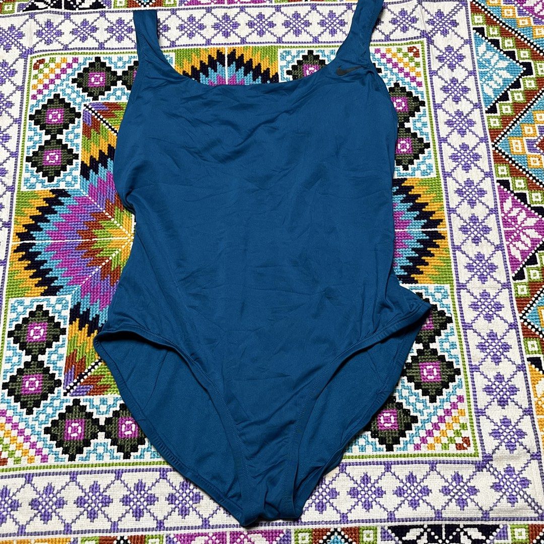 Nike Blue One-Piece Swimsuit (Category: Bikinis & Swimsuits) located in Dagupan City. Submitted by vernzkee (Listing ID 1466817989, Image 1). Description: - Brand: Nike - Style: One-piece swimsuit in solid blue - Neckline: Scoop neck with iconic black swoosh logo on the front strap - Back Design: Open back with a sporty striped accent band on the lower back - Fit & Cut: Standard cut leg openings with smooth, stretchy fabric for maximum comfort - 