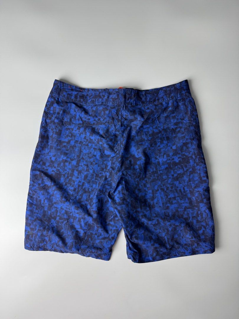 Nike Blue Pixel Pattern Swim Board Shorts Size 32 M (Category: Swim Trunks & Board Shorts) located in Cavite. Submitted by dracokidstuff (Listing ID 1466874404, Image 2). Description: Nike board shorts in blue with a pixelated all-over pattern. Bright orange drawstring waist and matching orange Nike logo on the left leg. Includes a zippered pocket on the left thigh with an orange zipper pull. Made of 100 percent polyester. Tag size 32, medium. Ma