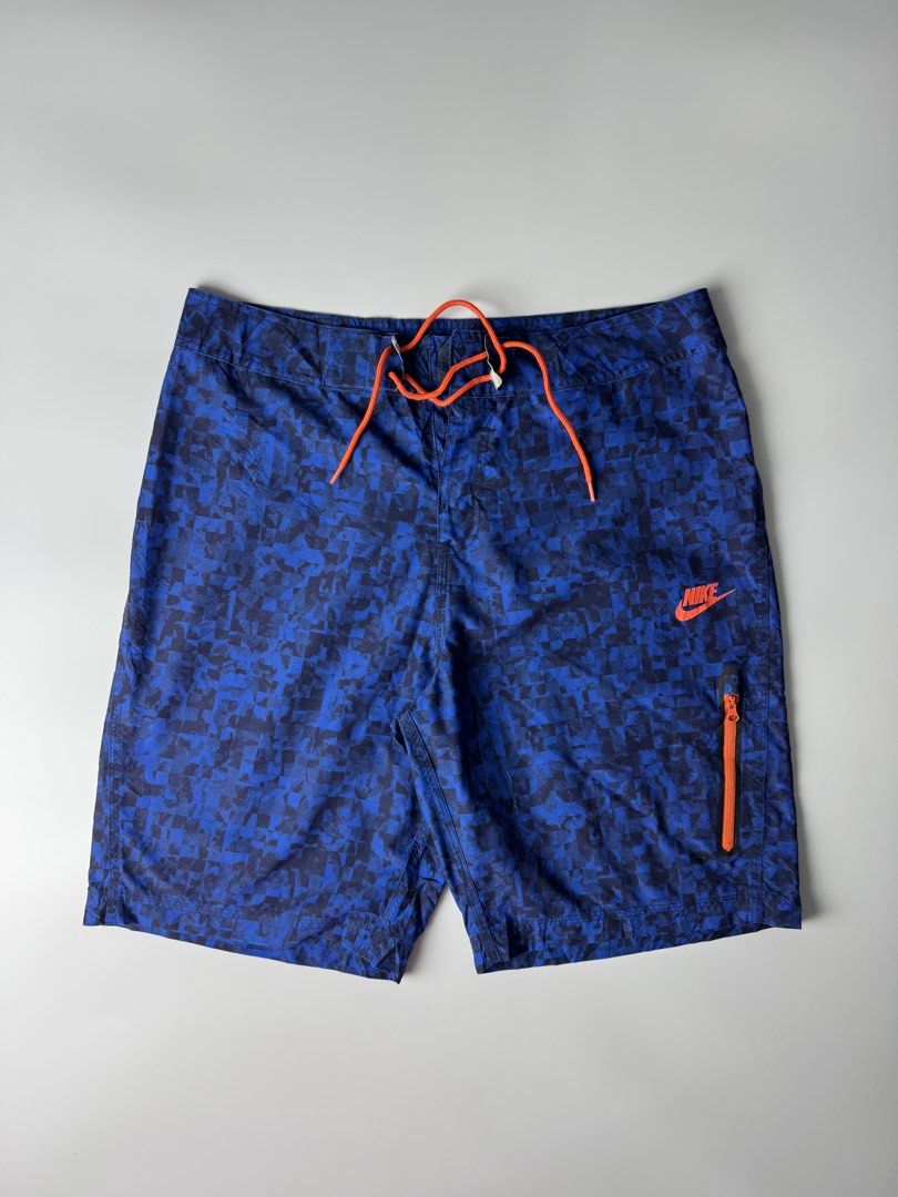 Nike Blue Pixel Pattern Swim Board Shorts Size 32 M (Category: Swim Trunks & Board Shorts) located in Cavite. Submitted by dracokidstuff (Listing ID 1466874404, Image 1). Description: Nike board shorts in blue with a pixelated all-over pattern. Bright orange drawstring waist and matching orange Nike logo on the left leg. Includes a zippered pocket on the left thigh with an orange zipper pull. Made of 100 percent polyester. Tag size 32, medium. Ma