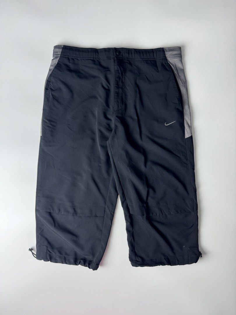 Nike Dri-FIT Black Capri Track Pants (Category: Shorts) located in Manila. Submitted by babygirly2k (Listing ID 1466875621, Image 2). Description: Nike Dri-FIT track pants in black, cropped capri length. Grey mesh panels running down the sides. Elastic waistband with a snap button closure. Adjustable drawstrings at the hem to switch up the fit. Embroidered white swoosh logo near the pocket. Lightweight athletic material. Back pocket features a sm
