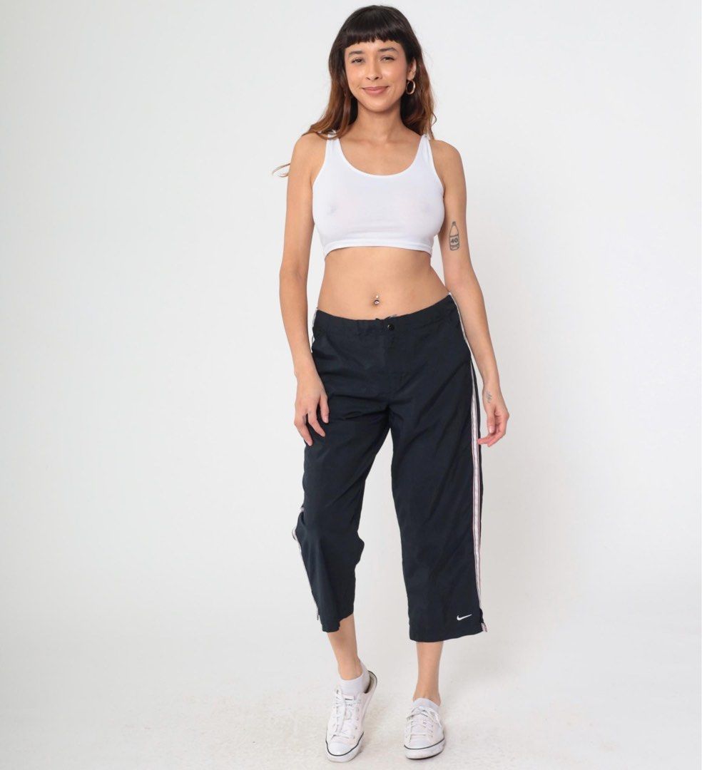 Nike Dri-FIT Black Capri Track Pants (Category: Shorts) located in Manila. Submitted by babygirly2k (Listing ID 1466875621, Image 1). Description: Nike Dri-FIT track pants in black, cropped capri length. Grey mesh panels running down the sides. Elastic waistband with a snap button closure. Adjustable drawstrings at the hem to switch up the fit. Embroidered white swoosh logo near the pocket. Lightweight athletic material. Back pocket features a sm