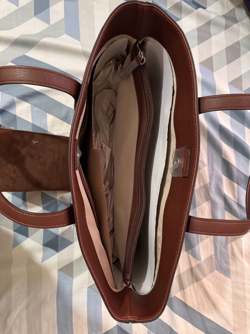 Nine West Brown Tote Bag with Pouch (Category: Tote Bags) located in Quezon City. Submitted by xtywop (Listing ID 1466844467, Image 3). Description: - Brand: Nine West - Color: Rich brown - Condition: Brand new with original store tags attached - Includes: Matching zippered suede pouch attached to the strap - Hardware: Silver-tone with subtle front branding - Interior: Multiple compartments with a convenient central zip divider - Extras: Stuffed 
