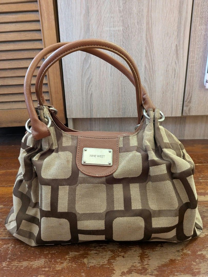 Nine West Geometric Pattern Brown Handbag (Category: Luxury Bags & Wallets) located in Pasig City. Submitted by cxdwr_ (Listing ID 1466839503, Image 1). Description: - Brand: Nine West - Design: Brown & beige geometric pattern fabric with brown leather-look trim - Closure: Secure zip-top - Straps: Comfortable dual strap design - Interior: Roomy with a structured bottom to hold its shape - Honest issues: Stains due to storage.