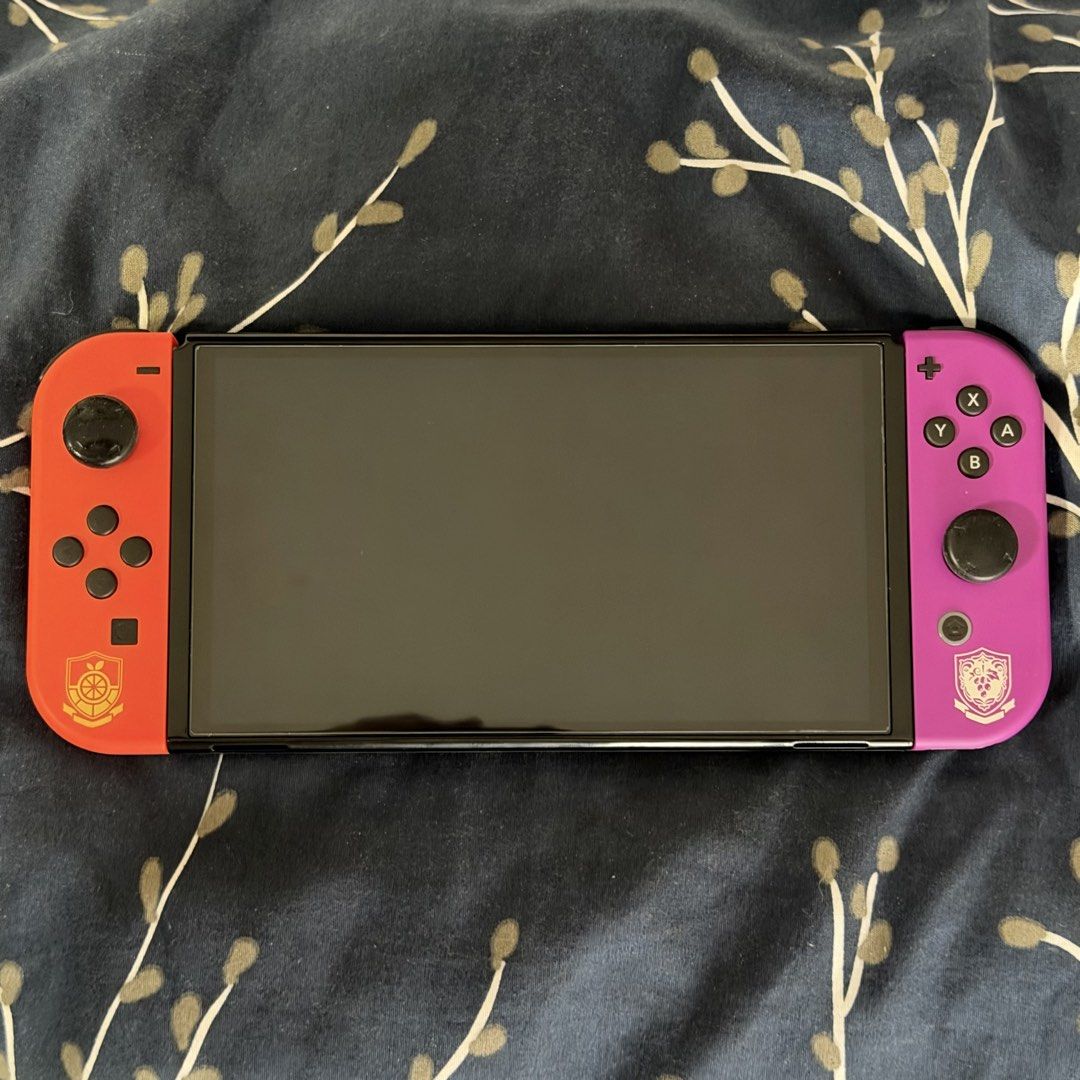 Nintendo Switch OLED Model Pokémon Scarlet & Violet Edition (Category: Nintendo) located in Taguig. Submitted by traderfromsouth (Listing ID 1466805150, Image 1). Description: - Special Edition Nintendo Switch Scarlet & Violet handheld console - Vibrant orange and purple Joy-Cons featuring academy crests - Custom graffiti-style artwork and starter Pokémon printed on the black back casing - Handheld console only NON JB / TEST ALL U WANT UPON MEETU