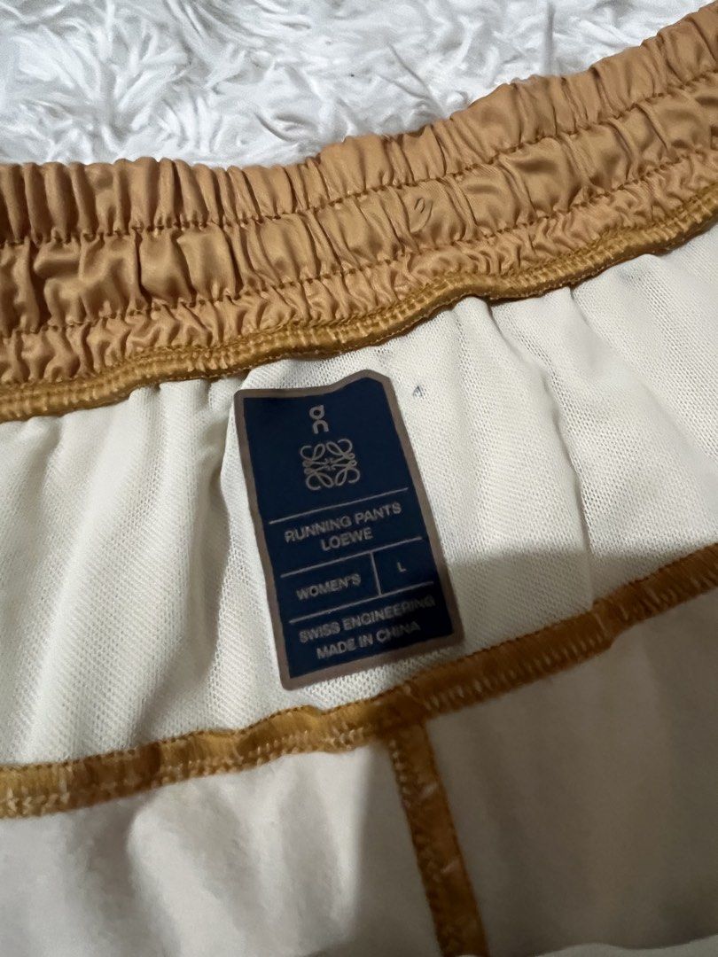 On x Loewe Running Pants (Category: Joggers) located in Caloocan City. Submitted by safewind.d918ef (Listing ID 1466924031, Image 3). Description: On x Loewe running pants in yellow and brown ombre tone. Women size large. Swiss engineering. Elastic waistband with adjustable black drawstring. Zip pocket on the side. Unique panel design and layered details down the legs. Fabric tags and interior branding clearly attached. Great athletic piece with 