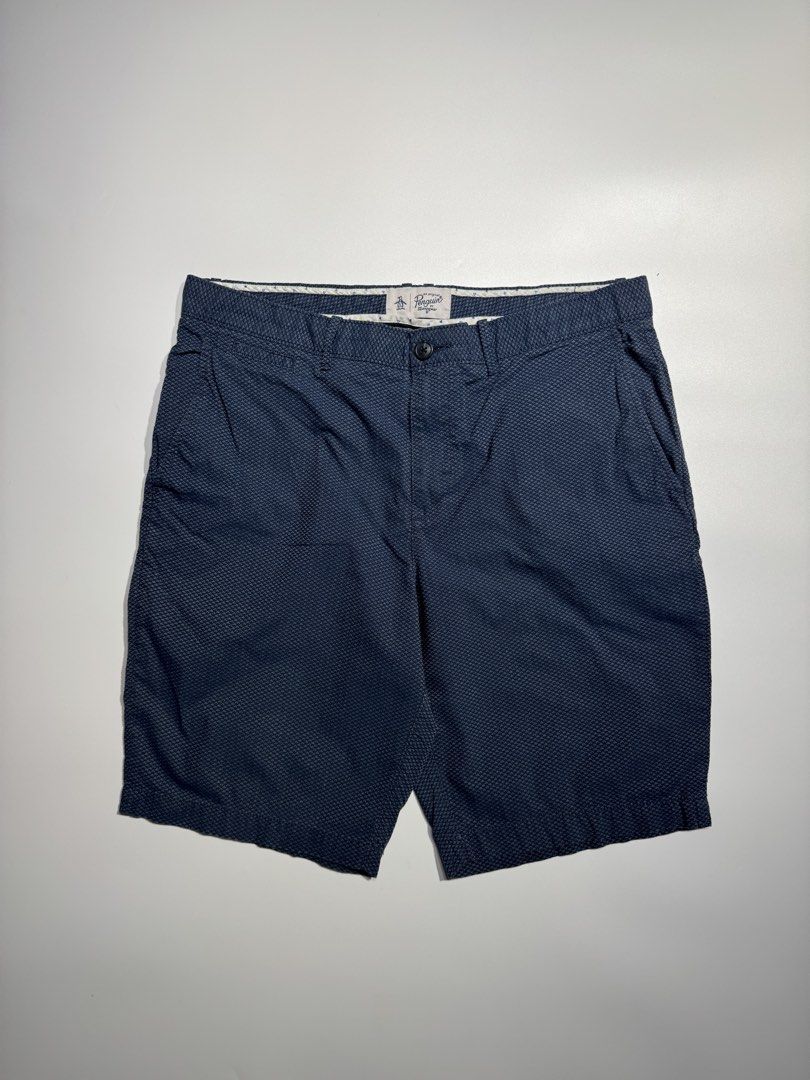 Original Penguin Blue Patterned Shorts (Category: Shorts) located in Cavite. Submitted by dracokidstuff (Listing ID 1466873189, Image 1). Description: - Brand: Original Penguin - Color: Dark Blue with textured geometric pattern - Measurements: 17 inches across waist, 21 inches outseam length - Closure: Button closure and zip fly - Pockets: Front hand pockets and two buttoned rear pockets - Details: Stylish patterned fabric lining along the interi