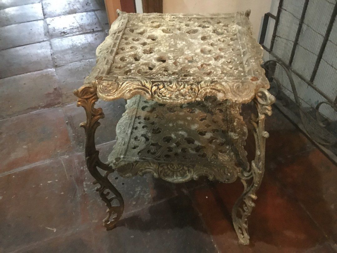 Ornate Cast Iron Two Tier Side Table Plant Stand (Category: Tables & Sets) located in Manila. Submitted by roberto.enriquez (Listing ID 1466967944, Image 1). Description: - Type: Two-tier metal stand / accent table - Material: Heavy cast iron with solid, sturdy structure - Design: Intricate scrollwork patterns, ornate curved legs, square tabletop, and matching lower shelf - Style: Classic antique French provincial or Victorian garden - Finish: Go