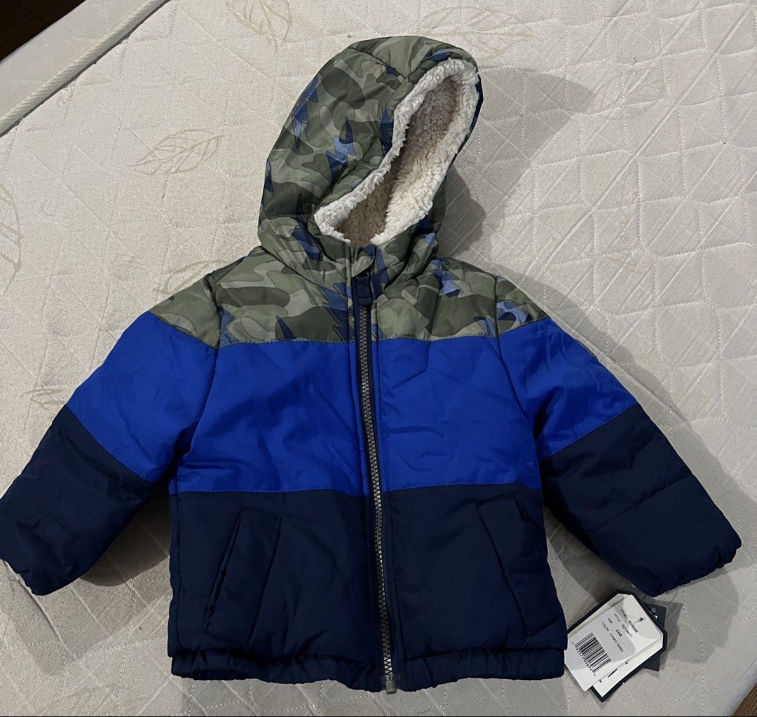OshKosh B'gosh Colorblock Camo Puffer Jacket 24M (Category: Babies & Kids Fashion) located in Pasig City. Submitted by mjqueen (Listing ID 1466936301, Image 1). Description: OshKosh B'gosh toddler puffer jacket in size 24M. Color block style with green camo top, royal blue middle, and navy bottom sections. Sherpa-lined hood for extra warmth. Water resistant and wind resistant material. Zipper guard protects the chin. Still has original retail tag
