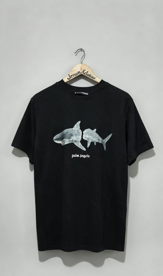 Palm Angels Shark Graphic Black Tee (Category: Tshirts & Polo Shirts ) located in San Francisco. Submitted by Intaw20 (Listing ID 1466935786, Image 3). Description: -Dimes 21 x 29 - Palm Angels black t-shirt -Authentication not Guaranteed - Split shark graphic with small white text logo on the chest - Large white gothic arched lettering printed across the back - Classic ribbed crew neck collar and short sleeves - Clean fabric with crisp, crack-fr