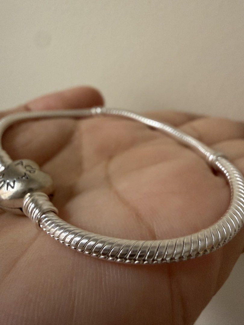Pandora Classic Silver Bracelet (Category: Bracelets) located in Taguig. Submitted by jmarieb_09 (Listing ID 1466794150, Image 2). Description: Pandora Classic Silver Bracelet with Heart Clasp + Character Charm Material: S925 Sterling Silver Sleek snake chain bracelet, heart-shaped clasp with 'Pandora' engraving, accompanied by a cute enamel character charm with pastel pink and green cap details Condition: Well-loved, good quality. Packaging not 