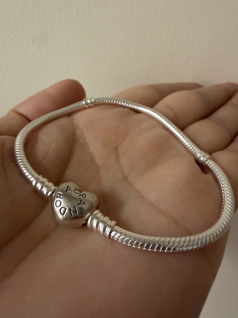 Pandora Classic Silver Bracelet (Category: Bracelets) located in Taguig. Submitted by jmarieb_09 (Listing ID 1466794150, Image 1). Description: Pandora Classic Silver Bracelet with Heart Clasp + Character Charm Material: S925 Sterling Silver Sleek snake chain bracelet, heart-shaped clasp with 'Pandora' engraving, accompanied by a cute enamel character charm with pastel pink and green cap details Condition: Well-loved, good quality. Packaging not 