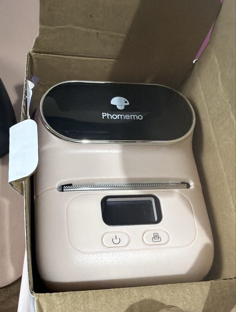 Phomemo Mini Thermal Pocket Printer (Category: Printers, Scanners & Copiers) located in Pasig City. Submitted by preloved_items_roche (Listing ID 1466775378, Image 1). Description: - Authentic Phomemo mini thermal pocket printer in a cute light pink shade - Wireless Bluetooth connectivity for easy printing of notes and labels - Compact and lightweight design, fits easily in any bag - Convenient front power and feed buttons with a built-in paper c