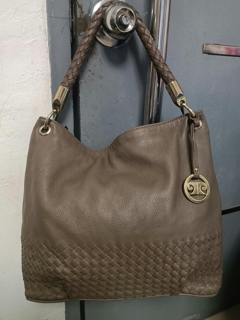 Pierre Cardin Paris hobo shoulder bag (Category: Shoulder Bags) located in Manila. Submitted by reneemaygo42069 (Listing ID 1466882143, Image 1). Description: - Color: Taupe - Material: Soft leather - Handle: Single braided handle in matching brown - Design: Intricate woven leather pattern on the lower section - Hardware: Gold-tone with a chic dangling circular charm - Interior: Spacious main compartment - Style: Slouchy hobo shoulder bag, great 