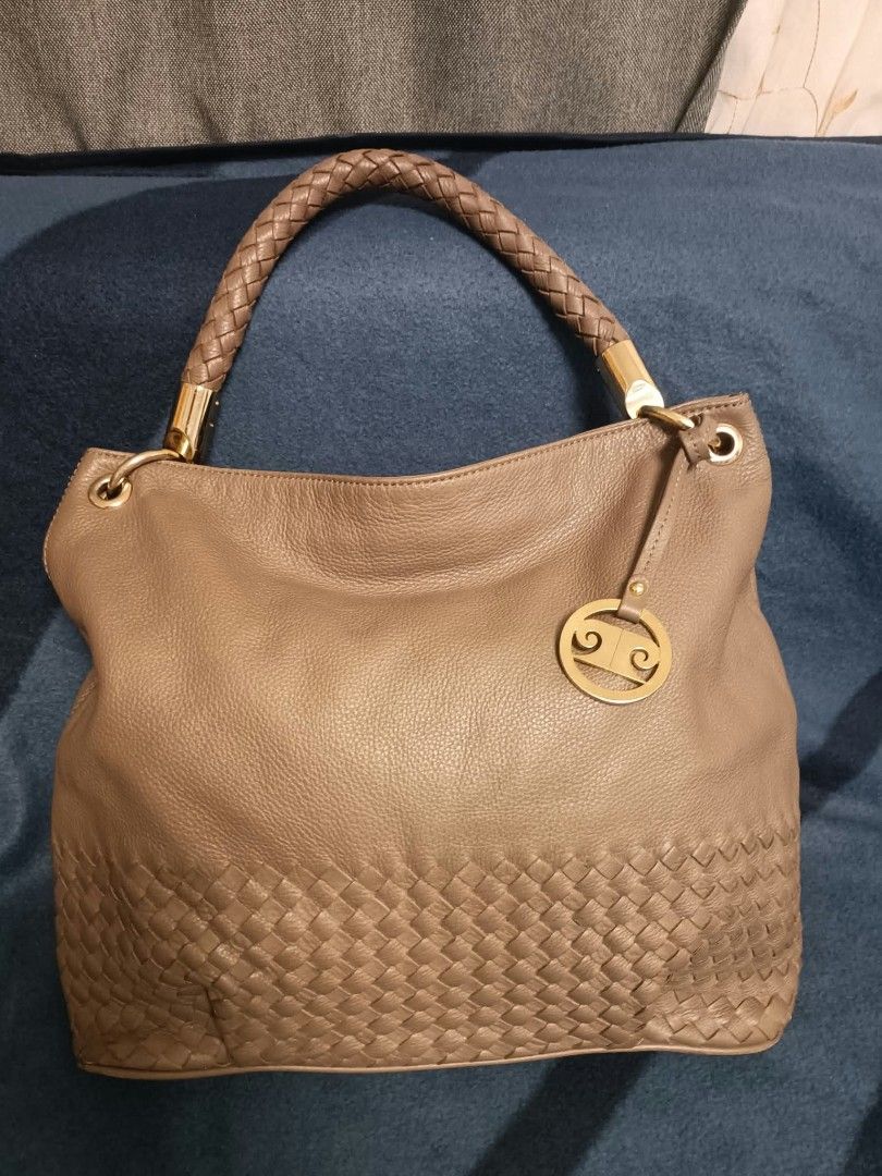 Pierre Cardin Paris hobo shoulder bag (Category: Shoulder Bags) located in Manila. Submitted by reneemaygo42069 (Listing ID 1466882143, Image 2). Description: - Color: Taupe - Material: Soft leather - Handle: Single braided handle in matching brown - Design: Intricate woven leather pattern on the lower section - Hardware: Gold-tone with a chic dangling circular charm - Interior: Spacious main compartment - Style: Slouchy hobo shoulder bag, great 