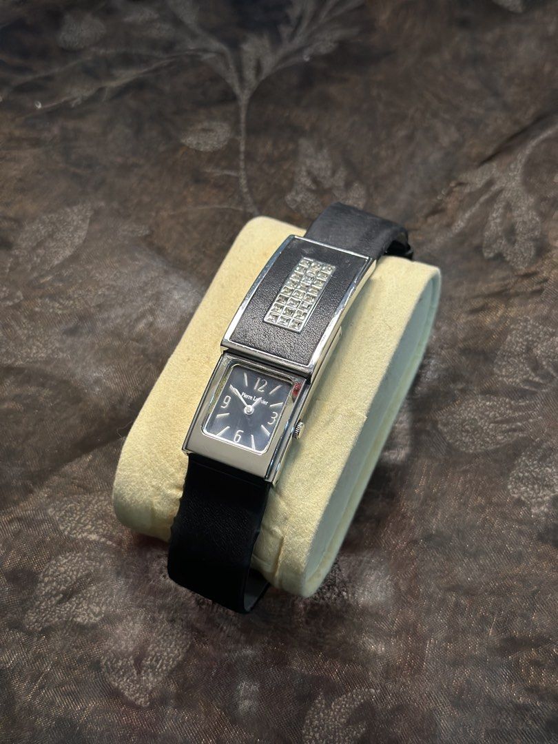 Pierre Lannier 022A6 Women's Rectangular Watch (Category: Women's Watches) located in Manila. Submitted by tenshiii185 (Listing ID 1466902511, Image 1). Description: - Brand: Pierre Lannier (Made in France) - Model: 022A6 - Design: Chic rectangular silver-tone case with a dark dial - Accents: Unique linked design with sparkling small crystals on the upper section - Markers: Simple dial markers at 3, 6, 9, and 12 o'clock - Strap: Classic black lea