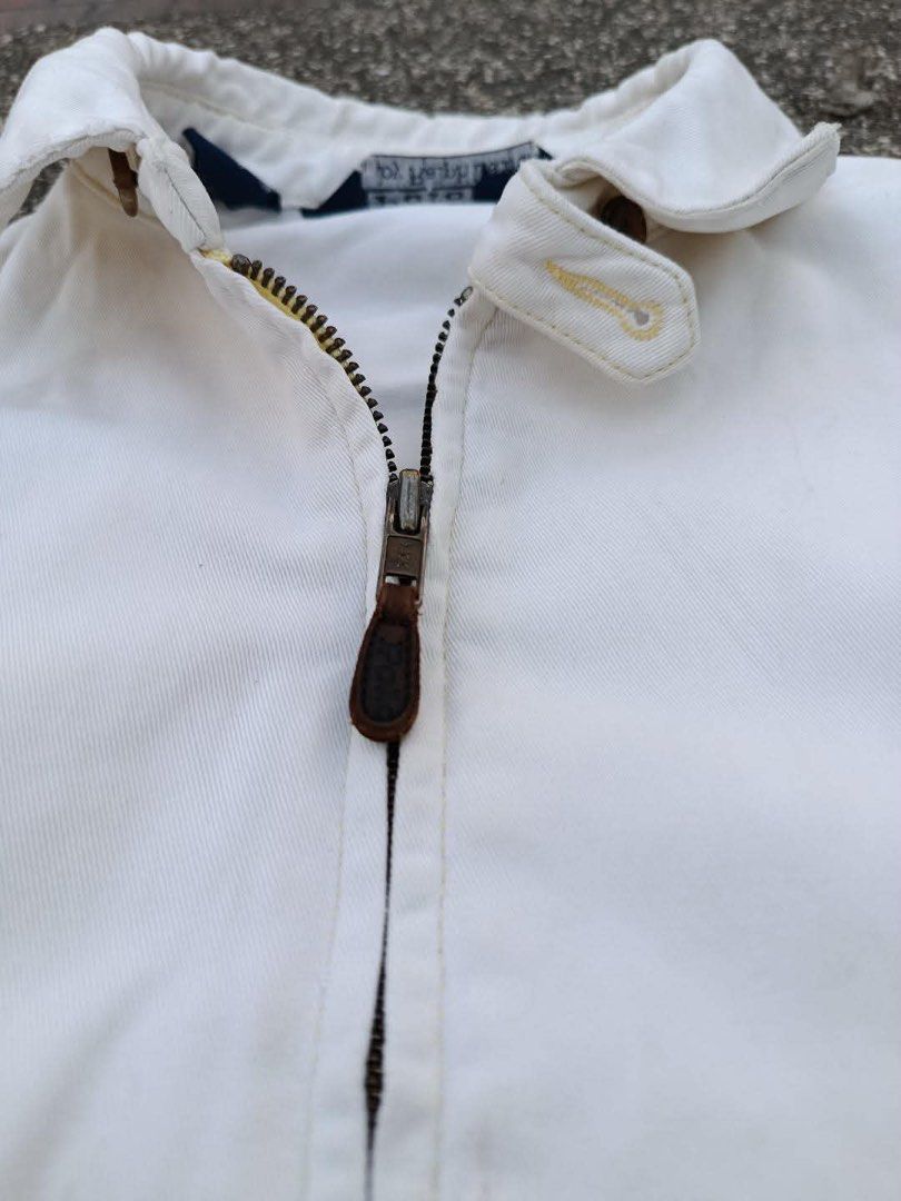 Polo by Ralph Lauren White Jacket (Category: Coats, Jackets and Outerwear) located in Manila. Submitted by luckyhorse.f804d6 (Listing ID 1466877613, Image 3). Description: - Brand: Polo by Ralph Lauren - Color: White with dark blue embroidered pony logo - Size: Medium (tag inside collar) - Material: 100% cotton (Made in Thailand) - Features: Full zip-up closure with leather pull, classic collar, front pockets, and elastic cuffs/hem - Condition: E