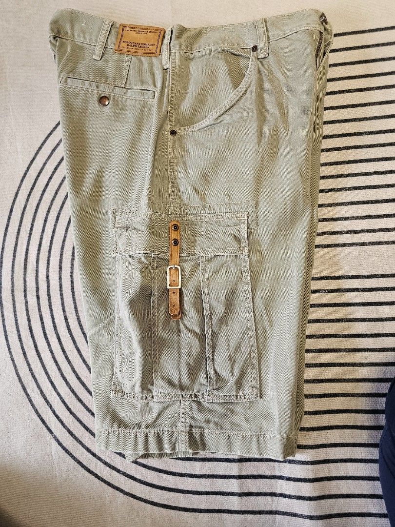 Polo Jean Cargo Shorts (Category: Shorts) located in Baguio. Submitted by kayeonlineshop (Listing ID 1466867441, Image 3). Description: vintage Polo Jeans Co. Ralph Lauren military-style tactical cargo shorts. [1] These shorts feature a rugged twill/canvas construction with deep front slash pockets, large buttoned side cargo utility pockets, and distinctive adjustable leather straps with metal buckles on the sides for a tactical aesthetic. w34l23