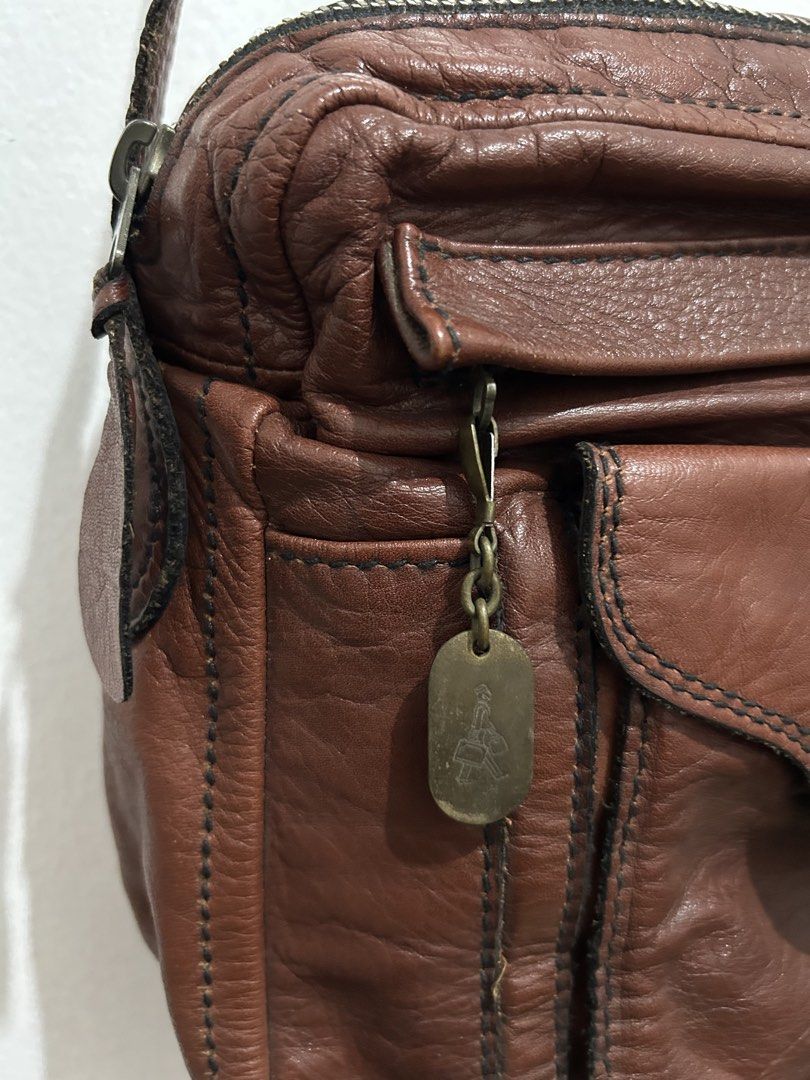 Porter Brown Leather Crossbody Bag (Category: Cross-body Bags) located in Angeles City. Submitted by cassey_phoenix (Listing ID 1466882740, Image 3). Description: - Brand: Porter - Material: Supple textured brown leather with contrast stitching - Strap: Adjustable shoulder strap with sturdy metal hardware - Storage: Multiple exterior zipper and flap pockets - Hardware: Brass-toned zipper pulls and YKK zippers throughout - Details: Signature Porte