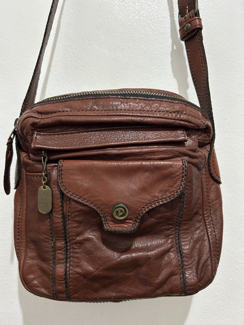 Porter Brown Leather Crossbody Bag (Category: Cross-body Bags) located in Angeles City. Submitted by cassey_phoenix (Listing ID 1466882740, Image 2). Description: - Brand: Porter - Material: Supple textured brown leather with contrast stitching - Strap: Adjustable shoulder strap with sturdy metal hardware - Storage: Multiple exterior zipper and flap pockets - Hardware: Brass-toned zipper pulls and YKK zippers throughout - Details: Signature Porte
