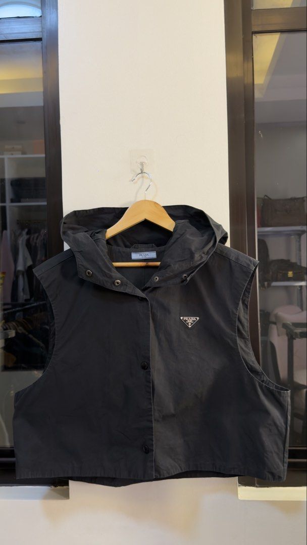 Prada Black Hooded Vest Size M (Category: Sleeveless) located in Paranaque City. Submitted by mykapoynton (Listing ID 1466960583, Image 2). Description: Prada Black Hooded Vest Size M - Color: Black - Size: Medium - Snap button front closure - Two front utility pockets - Iconic Prada triangle logo plaque on chest - Drawstring hood & sleeveless design - Clean interior lining with branding tag - Perfect layering piece for cooler weather.