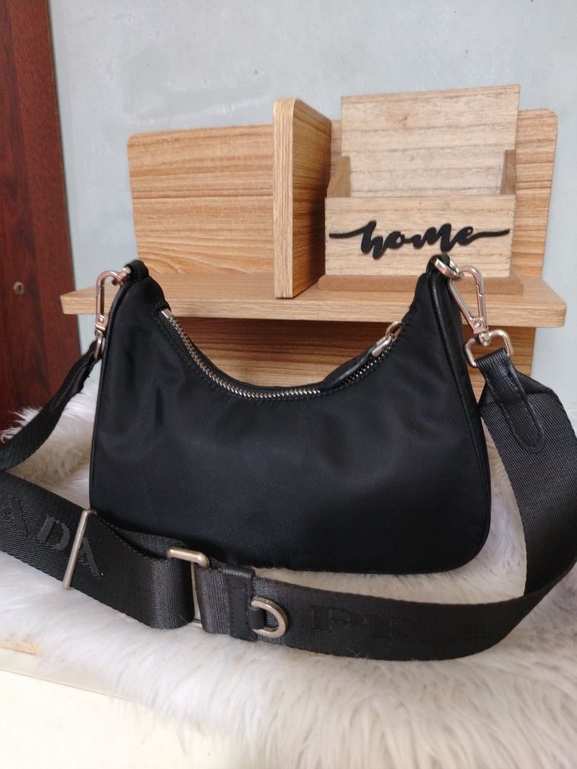 Prada Black Nylon Crossbody Shoulder Bag (Category: Luxury Bags & Wallets) located in Lucena. Submitted by gracious_chin0436 (Listing ID 1466793369, Image 2). Description: - Features the iconic triangular logo plaque on the front - Adjustable branded webbing strap with silver-toned hardware and clasp closures - Secure zip top closure for daily essentials - Clean edges and neat stitching throughout - Compact size, perfect for everyday casual or sm