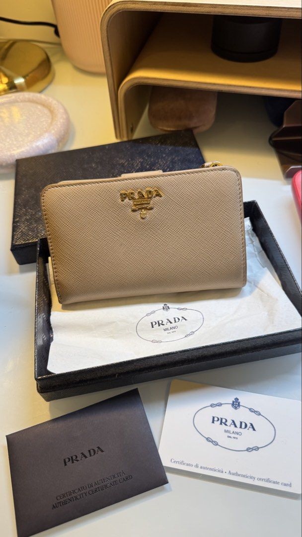 Prada Saffiano Leather Compact Wallet in Cammeo Multicolor (Category: Luxury Bags & Wallets) located in Antipolo. Submitted by lala.lysa (Listing ID 1466957249, Image 1). Description: Guaranteed authentic. - Brand: Prada - Material: Premium Saffiano leather - Hardware: Gold-tone with Prada Milano logo plate - Compartments: Card slots and secure zip coin pocket - Inclusions: Original black box, authenticity card - Condition: Well-maintained.