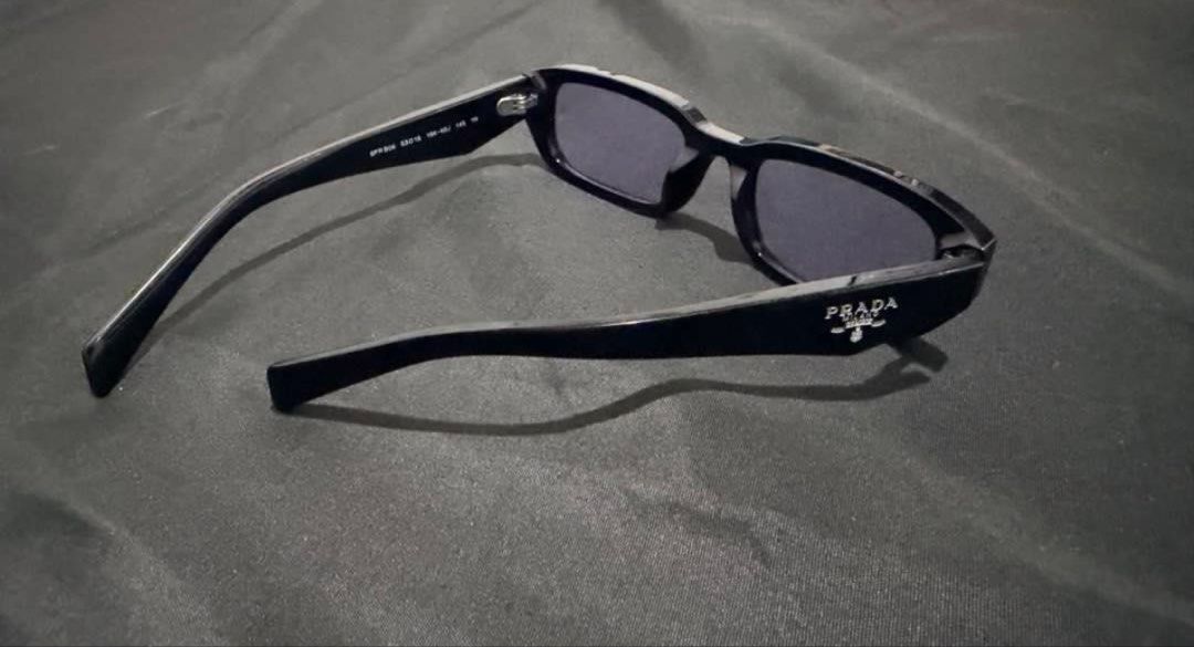 Prada SPR B06 Black Sunglasses (Original) (Category: Sunglasses & Eyewear) located in Manila. Submitted by casayuranhannahmae.1 (Listing ID 1466777207, Image 3). Description: - Original Prada sunglasses (Model SPR B06) - Chic black frame with stylish light purple lenses - Comes with original Prada case and cleaning cloth - Lens Width: 53mm, Bridge: 19mm, Temple Length: 145mm - A must-have accessory to elevate your look! - Inclusion: Prada sunglas