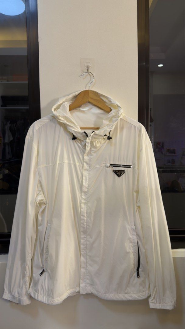 Prada White Hooded Windbreaker Jacket Size 56 (Category: Coats, Jackets and Outerwear) located in Paranaque City. Submitted by mykapoynton (Listing ID 1466960127, Image 2). Description: Prada White Hooded Windbreaker Jacket - Item: Hooded Windbreaker - Color: Clean White - Size: 56 (Tag inside) - Features: Full front zip, adjustable drawstrings at the hood - Pockets: Zippered chest pocket with metal logo plaque and two side zip pockets - Details: