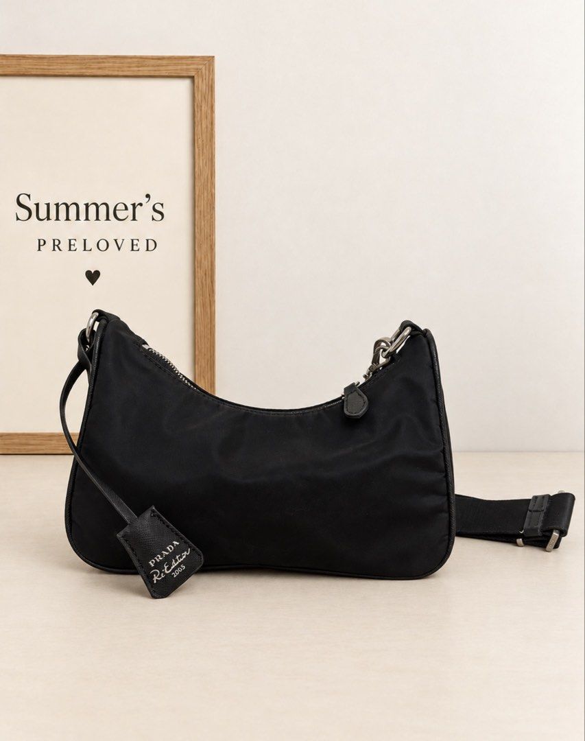 Pradung Re edition 2005 (Category: Tote Bags) located in Taguig. Submitted by summers.preloved (Listing ID 1466825547, Image 3). Description: 👜 BAG DETAILS 🖤 Color: Black with silver-tone hardware. 🧵 Exterior: Smooth nylon-look fabric with a soft sheen and matching textured trim. Exact fabric composition and leather type cannot be verified from photos alone. 👛Shape: Compact, softly structured shoulder bag with a curved top. 🔺 Branding: Prada