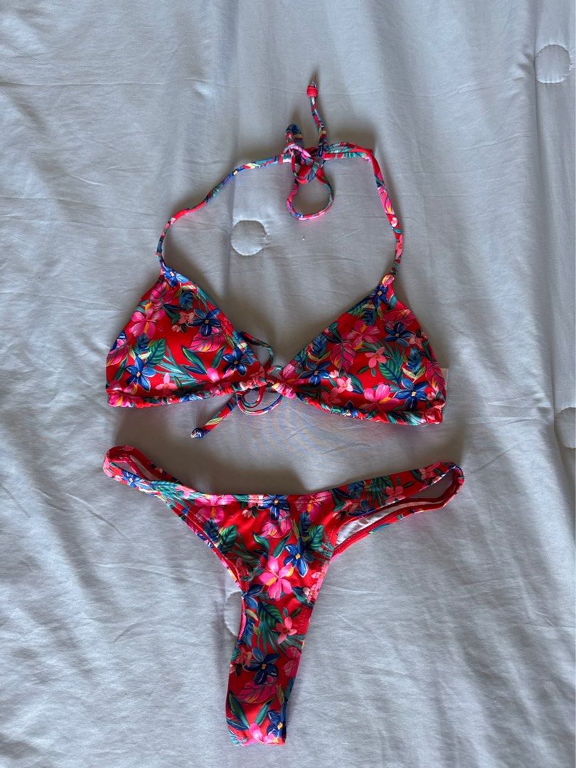 Primark Floral Print Two-Piece Bikini 2XS (Category: Bikinis & Swimsuits) located in Manila. Submitted by chicclosetco (Listing ID 1466800752, Image 3). Description: - Brand: Primark - Size: 2XS (tag attached) - Color/Pattern: Red with vibrant blue and pink floral print - Top: Halterneck triangle style with adjustable ties - Bottoms: Matching cheeky cut with trendy double side straps - Condition: Brand new, unworn, and clean - Material: Lightweig