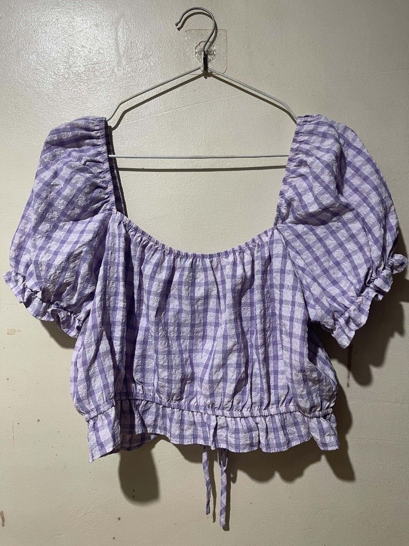 Primark Purple Gingham Crop Blouse UK 14 (Category: Blouses) located in Cebu City. Submitted by elon_888 (Listing ID 1466961519, Image 2). Description: - Brand: Primark - Size: UK 14 / EUR 42 / USA 10 - Color/Pattern: Purple and white gingham - Material: Textured seersucker fabric - Design: Square neckline, puff sleeves with ruffled cuffs, and center front ruching - Fit: Elasticated shoulders and back neckline with a tie drawstring hem.