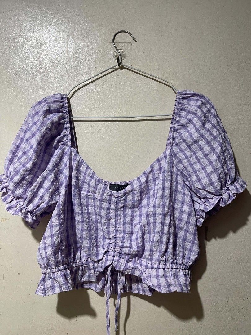 Primark Purple Gingham Crop Blouse UK 14 (Category: Blouses) located in Cebu City. Submitted by elon_888 (Listing ID 1466961519, Image 1). Description: - Brand: Primark - Size: UK 14 / EUR 42 / USA 10 - Color/Pattern: Purple and white gingham - Material: Textured seersucker fabric - Design: Square neckline, puff sleeves with ruffled cuffs, and center front ruching - Fit: Elasticated shoulders and back neckline with a tie drawstring hem.