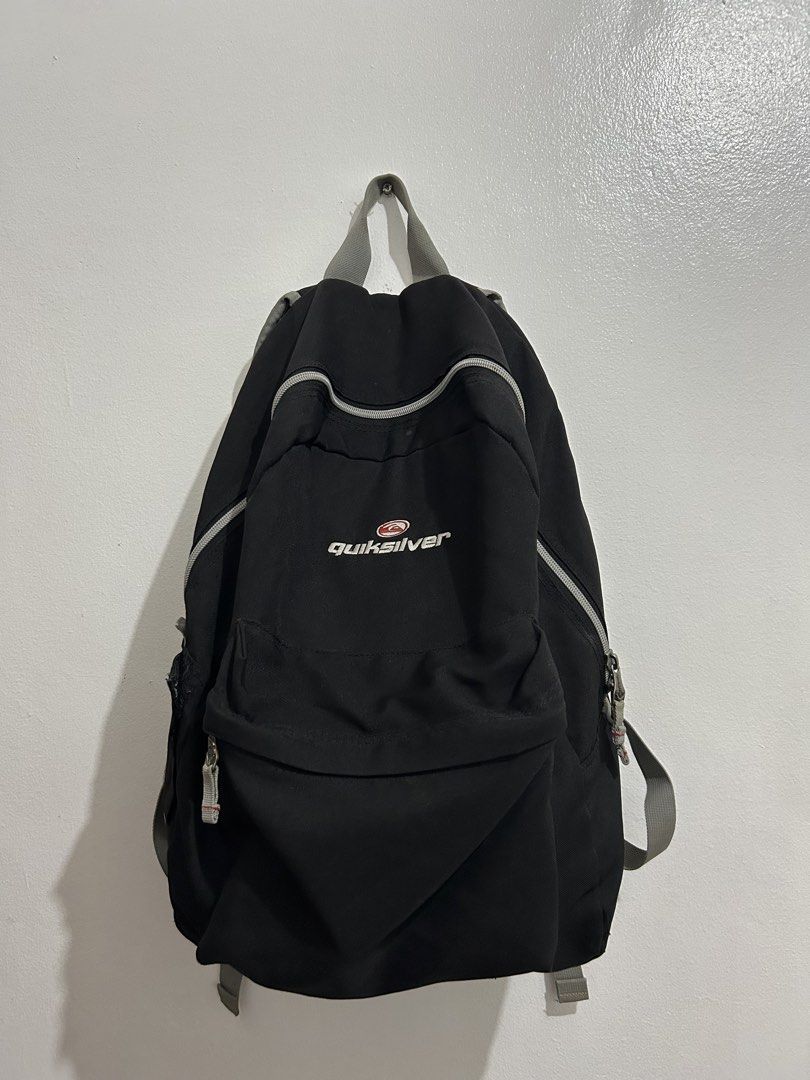 Quiksilver Black Backpack with Grey Straps (Category: Backpacks) located in Angeles City. Submitted by cassey_phoenix (Listing ID 1466882084, Image 1). Description: - Brand: Quiksilver - Color: Black with grey straps and zipper details - Logo: Embroidered front logo and red side tag - Compartments: Main compartment and front zippered pocket - Features: Adjustable shoulder straps and top hanging loop - Material: Durable fabric construction - Condi