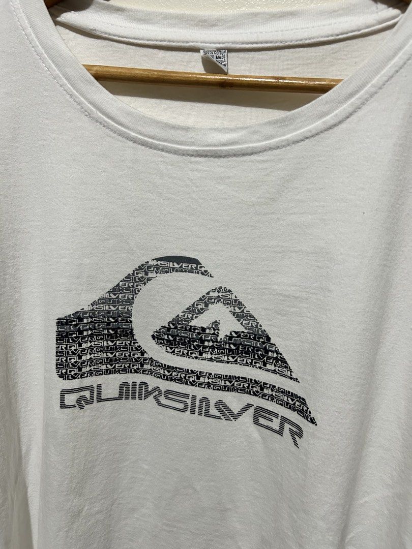 Quiksilver White Graphic T-Shirt (Category: Tshirts & Polo Shirts ) located in Angeles City. Submitted by johngamboa (Listing ID 1466961379, Image 2). Description: - Brand: Quiksilver - Color: White - Material: 100% Cotton - Fit: Standard fit, crew neck - Design: Classic chest logo with text pattern - Style: Casual, easy to pair with jeans or shorts.