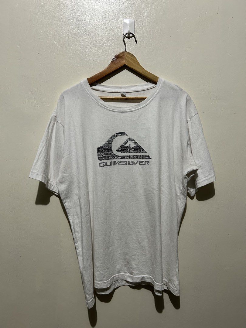 Quiksilver White Graphic T-Shirt (Category: Tshirts & Polo Shirts ) located in Angeles City. Submitted by johngamboa (Listing ID 1466961379, Image 1). Description: - Brand: Quiksilver - Color: White - Material: 100% Cotton - Fit: Standard fit, crew neck - Design: Classic chest logo with text pattern - Style: Casual, easy to pair with jeans or shorts.