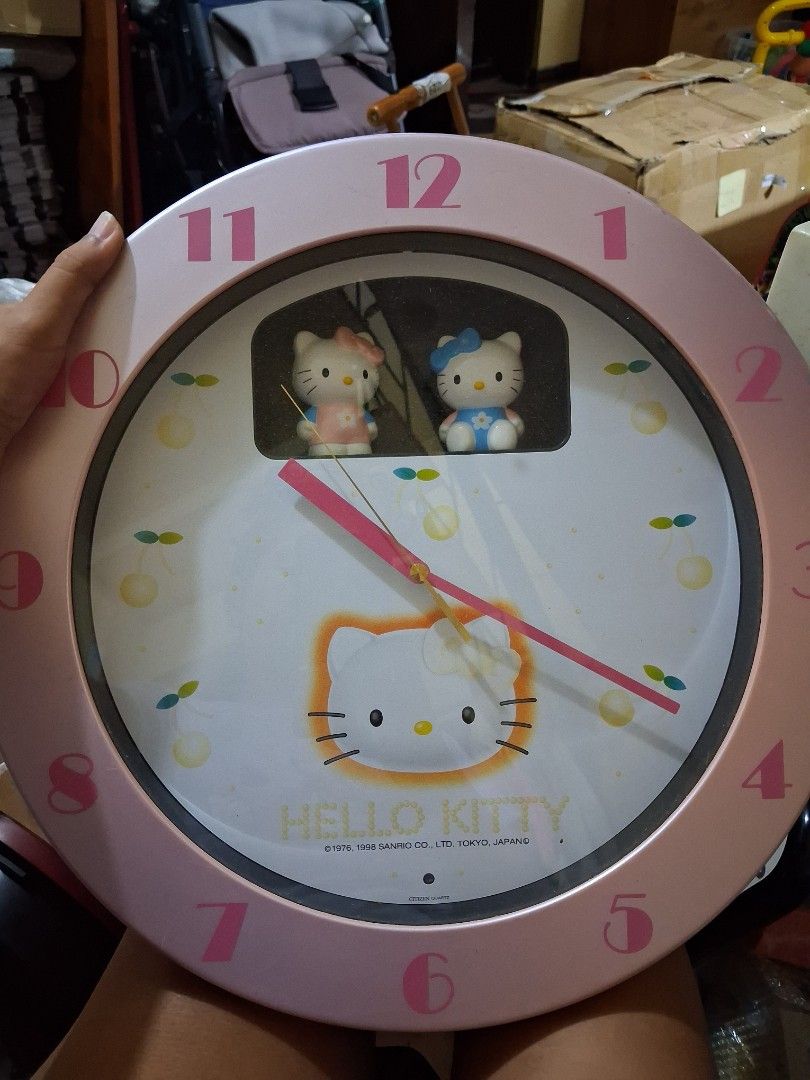 Sanrio Hello Kitty 1998 Vintage Wall Clock (Category: Clocks) located in Manila. Submitted by hellokitty88235 (Listing ID 1466898796, Image 1). Description: - Authentic 1998 vintage Sanrio Kitty wall clock - Officially licensed by Citizen Quartz - Charming pink design with miniature figures on the left panel - Large pink numbers printed around the outer rim - Battery-operated for easy placement - Perfect for retro room setups and Sanrio collector