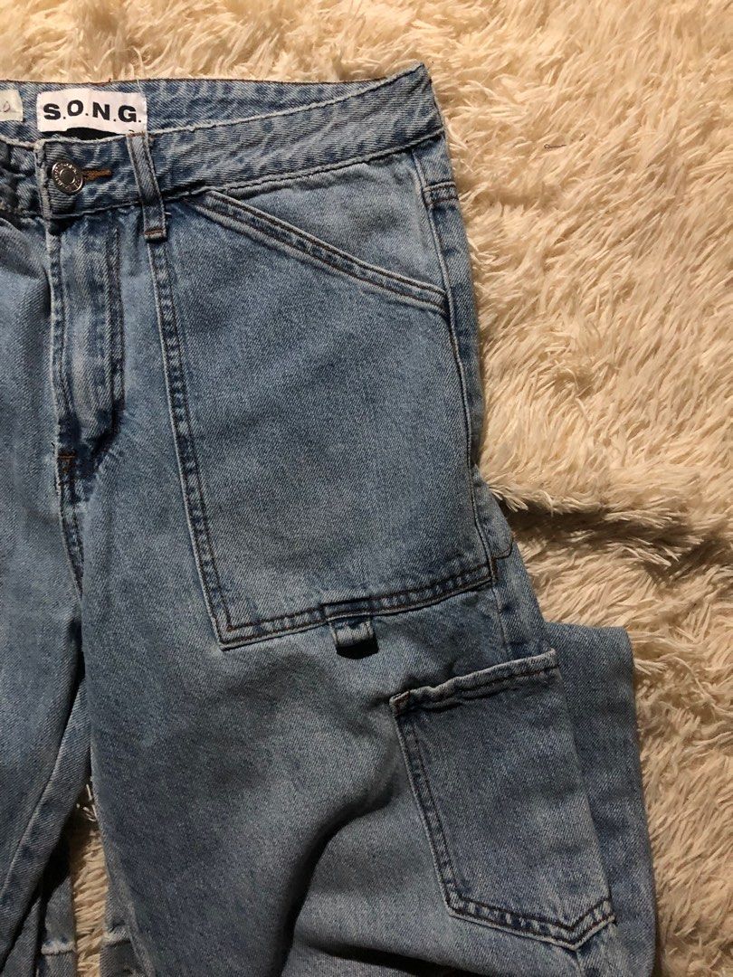 S.O.N.G. Light Blue Cargo Jeans (Category: Jeans) located in Maria Aurora. Submitted by kylerikathriftshop101010 (Listing ID 1466924908, Image 3). Description: 32-33 waist Hem 10 - Brand: S.O.N.G. - Wash: Light wash denim - Fit: Relaxed fit through the legs with classic straight hems - Closure: Standard button and zipper fly - Features: Multiple utility pockets on the legs and a side hammer loop - Details: Clean stitching around the waist and poc