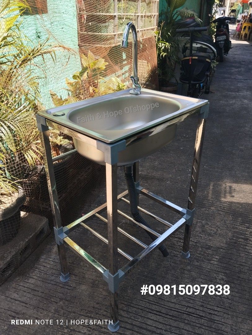 Stainless Steel Kitchen Sink with Stand (Category: Bathroom & Kitchen Fixtures) located in Manila. Submitted by jamfrimzy089458 (Listing ID 1466842875, Image 2). Description: Stainless steel single bowl sink mounted on a sturdy metal frame stand. Includes a tall gooseneck faucet, flexible drainage hose, and a lower storage shelf for kitchen essentials. Easy to assemble, compact setup suitable for indoor or outdoor washing areas. Sturdy legs keep 