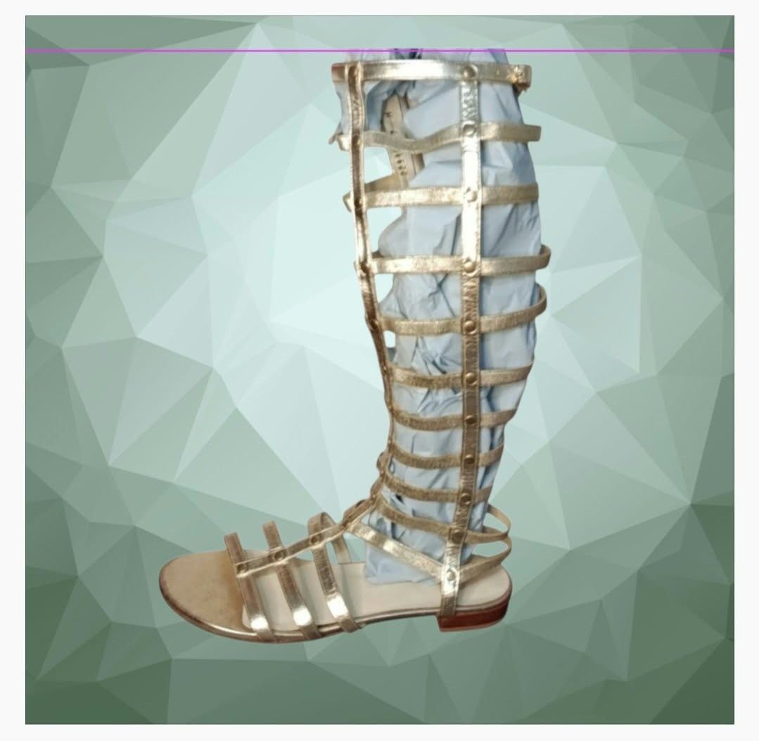 Stuart Weitzman Gold Knee-High Gladiator Sandals (Category: Sneakers & Footwear) located in Paranaque City. Submitted by calm_youngstore7 (Listing ID 1466946034, Image 1). Description: Stuart Weitzman Metallic Leather Gladiator Flat Sandals in gold. This eye-catching design features a towering, knee-high caged silhouette constructed with structural metallic gold leather vertical bars and flexible horizontal straps that comfortably conform to the 