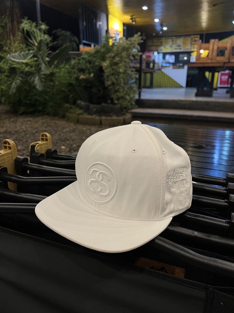 Stüssy White Snapback Hat Cap (Category: Caps & Hats) located in Manila. Submitted by wearurlux_wul (Listing ID 1466808267, Image 1). Description: - Brand: Stüssy - Color: White - Style: Snapback hat / Cap - Fit: Standard OS (One Size, Adjustable) - Material: 100% Cotton - Design: Stitched round logo on front, embroidered global cities (NYC, LA, Tokyo, London, Paris) on the side - Closure: Adjustable plastic snap with small woven logo tab - Condi