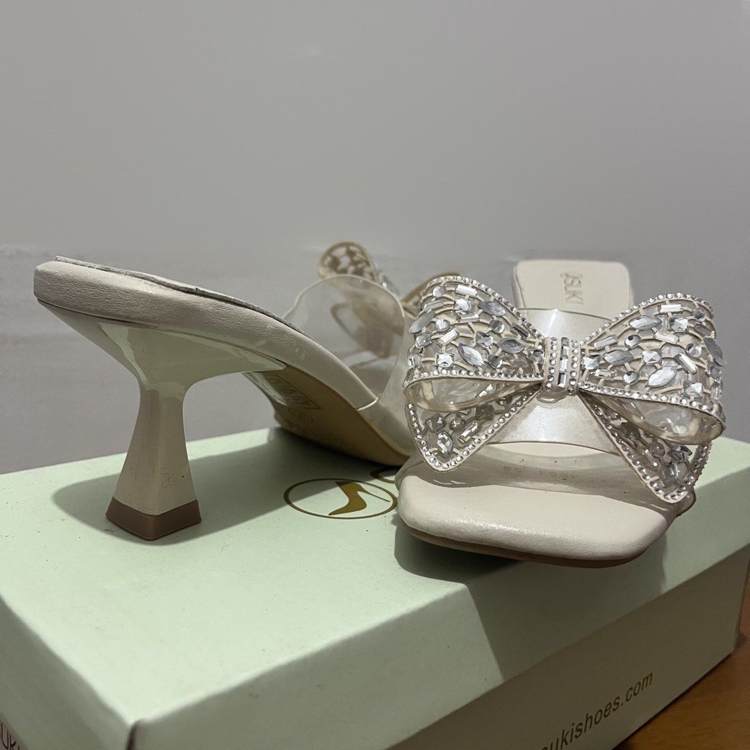 Suki Bone Rhinestone Bow Heels Size 35 (Category: Heels) located in Taguig. Submitted by 152hertz (Listing ID 1466857302, Image 2). Description: - Brand: Suki - Color: Bone (Off-White) - Size: 35 - Details: Clear strap with a large rhinestone bow, square toe, and stylish flare heel - Condition: Excellent, original box included - Source: Purchased directly from SM Store.
