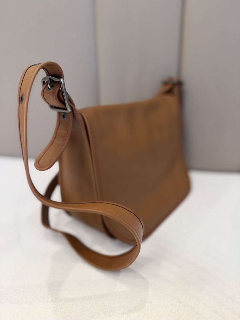 Tan leather shoulder bag with flap closure (Category: Shoulder Bags) located in Rizal. Submitted by je_resada (Listing ID 1466824145, Image 2). Description: - Material: Genuine tan leather with clean edge stitching - Closure: Flap top with a secure zippered main compartment - Interior: Bright orange fabric lining with a handy slip pocket - Exterior: Convenient back slip pocket for easy access - Strap: Adjustable shoulder strap complete with styli