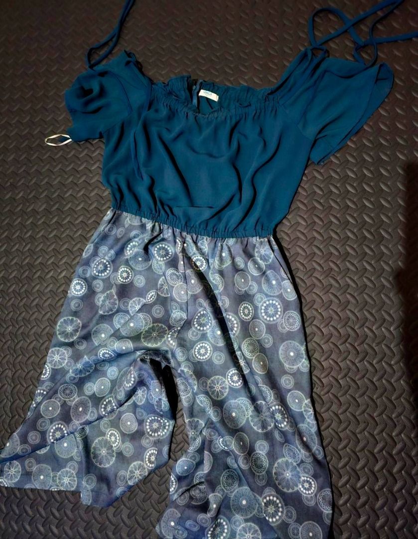 Teal and patterned blue jumpsuit size large (Category: Jumpsuits) located in Lapu Lapu. Submitted by goodstuff_cebu (Listing ID 1466948757, Image 1). Description: - Size: Large (as shown in photo) - Style: Easy pull-on design - Top: Teal with off-shoulder sleeves and string ties - Bottom: Dark blue with circular geometric patterns - Waist: Elastic waistband for a flattering gathered look - unused extra dress (pants style).