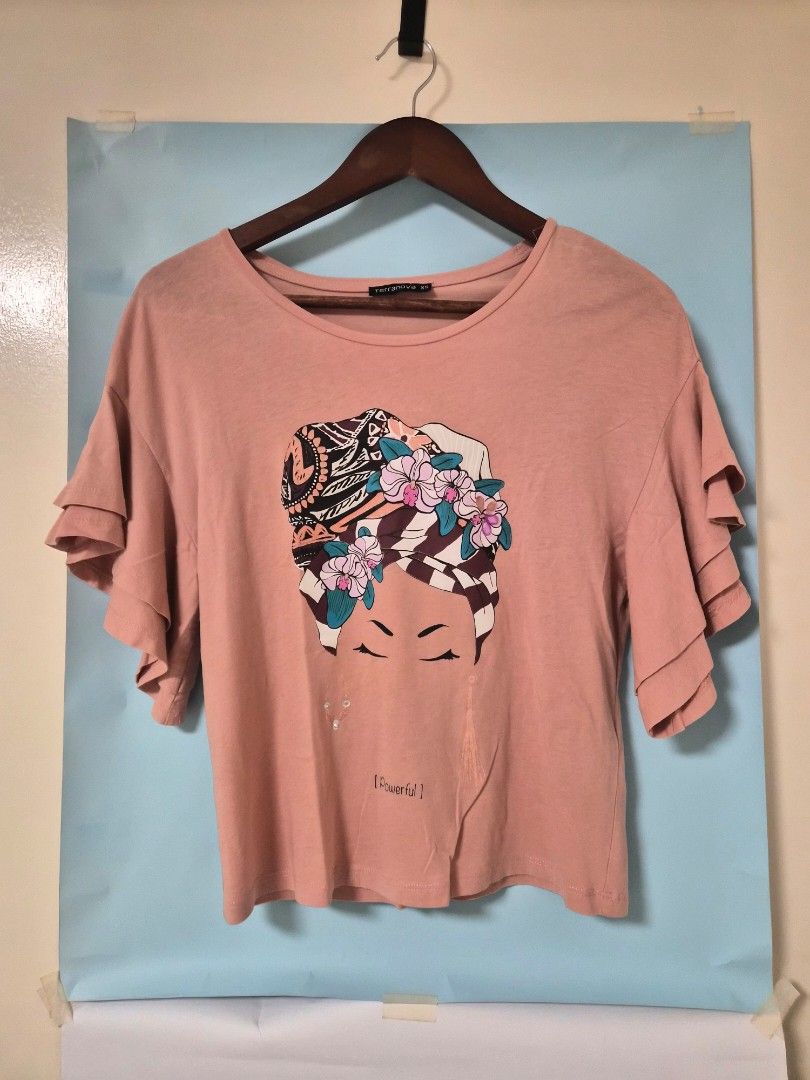 Terranova Pink Graphic T-shirt XS (Category: Shirts) located in Manila. Submitted by prelovedbyc.hannah (Listing ID 1466922708, Image 1). Description: - Brand: Terranova - Size: XS - Color: Pink - Sleeves: Short with layered ruffle details - Condition: Pre-loved with one tiny, faint spot and some missing gems (please refer to the photos).
