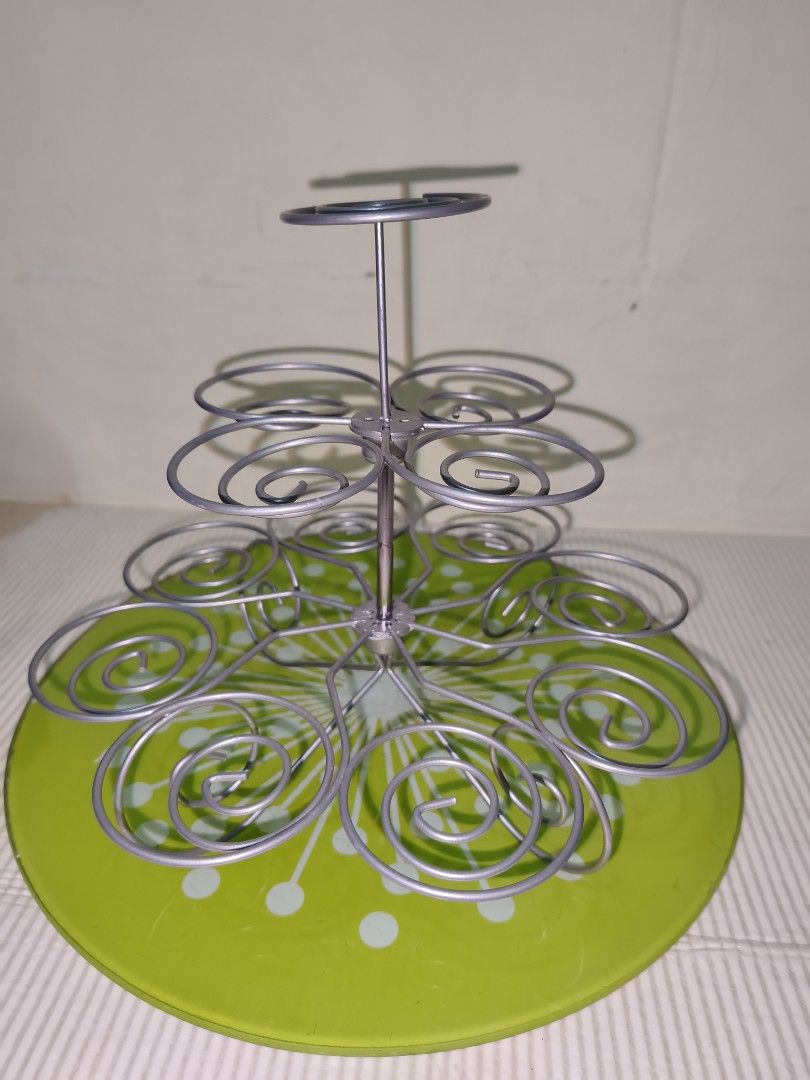 Tiered Metal Cupcake Stand with Green Base (Category: Bakeware) located in Manila. Submitted by reascheyss51406 (Listing ID 1466789389, Image 1). Description: - Multi-tier silver metal wire cupcake stand - Features a cheerful bright green baseplate with white polka dots - Spiral levels securely hold multiple cupcakes - Sturdy and durable metal construction - Easy to set up and take down - Ideal for birthday parties, bake sales, and tea gatherings