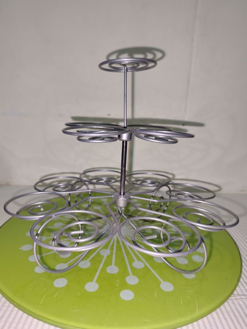 Tiered Metal Cupcake Stand with Green Base (Category: Bakeware) located in Manila. Submitted by reascheyss51406 (Listing ID 1466789389, Image 2). Description: - Multi-tier silver metal wire cupcake stand - Features a cheerful bright green baseplate with white polka dots - Spiral levels securely hold multiple cupcakes - Sturdy and durable metal construction - Easy to set up and take down - Ideal for birthday parties, bake sales, and tea gatherings