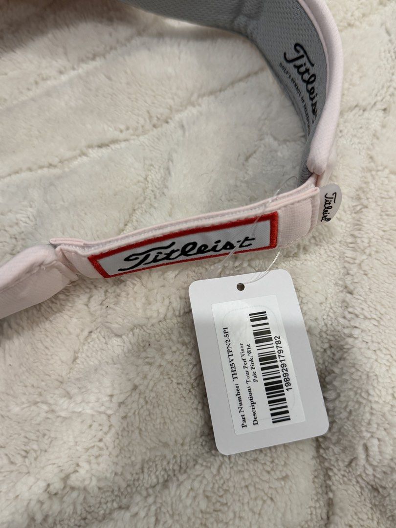 Titleist Tour Performance Visor Pale Pink / White (Category: Golf) located in Taytay. Submitted by kylalm (Listing ID 1466943741, Image 3). Description: - Brand new with original store tags attached - Authentic Titleist tour performance visor - Pale pink and white colorway - Embroidered Titleist logo on the front - Pro V1 embroidery on the side - Adjustable strap with a red-bordered Titleist tag at the back.